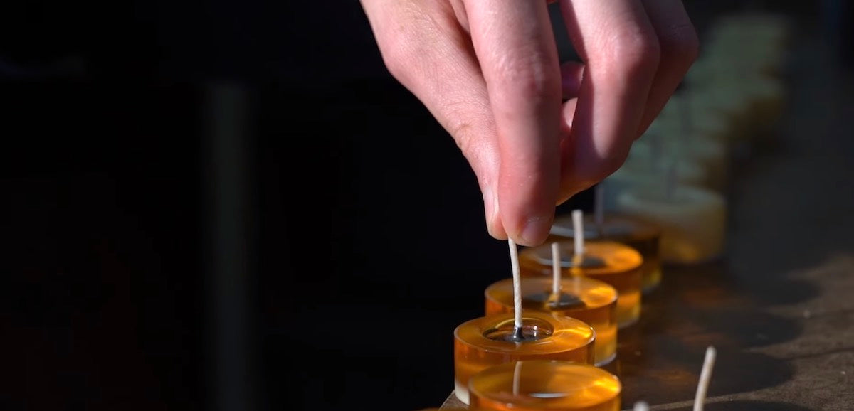 hand holding a wick, making tea light candles, pure beeswax candles