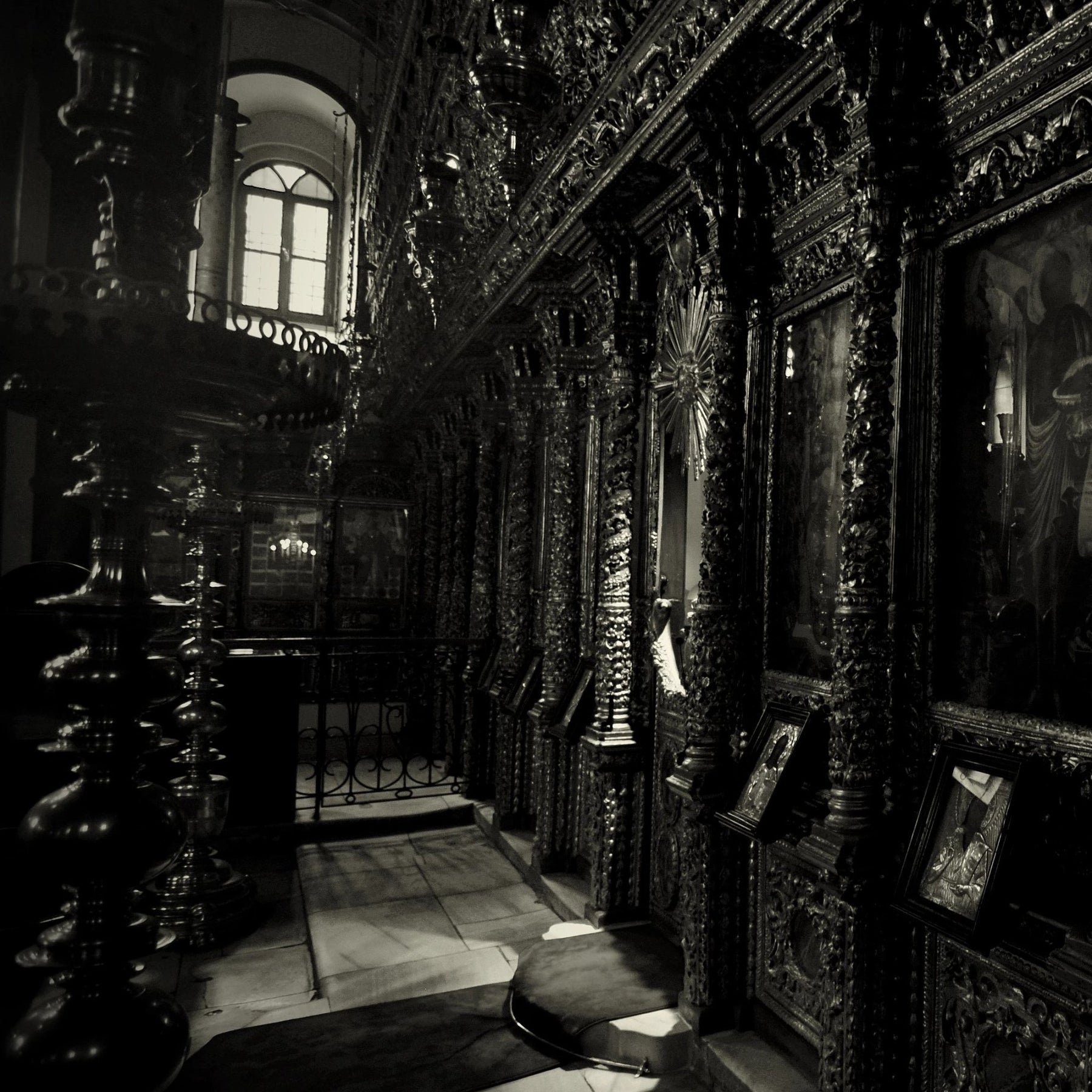 A dimly lit church with ornate wooden rafters and icons on the walls.
