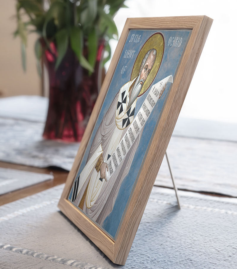 Framed religious icon on a table with a plant in the background