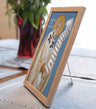 Framed religious icon with a blue background on a table