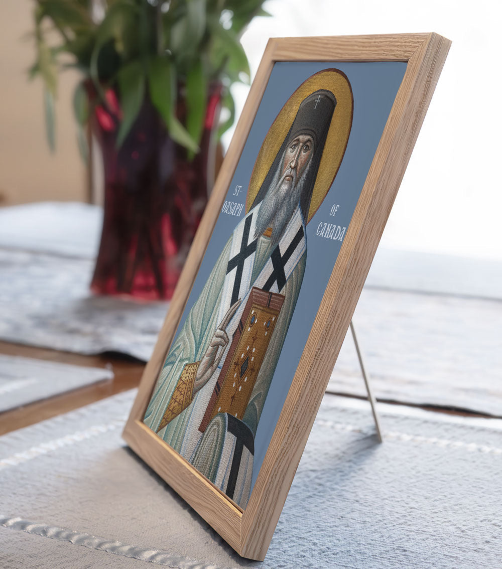 Framed religious icon of a saint on a table with a plant in the background