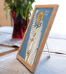 Framed icon on a table with a plant in the background