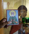 Hand holding a small icon of St. Seraphim of Sarov with a blurred background