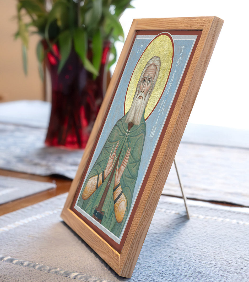 Framed icon of St. Seraphim of Sarov in a wooden frame with a blurred background