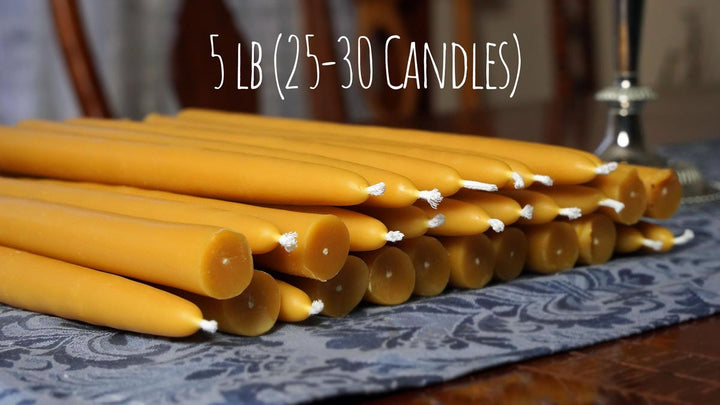 a group of 100% pure beeswax candles on a blue tablecloth