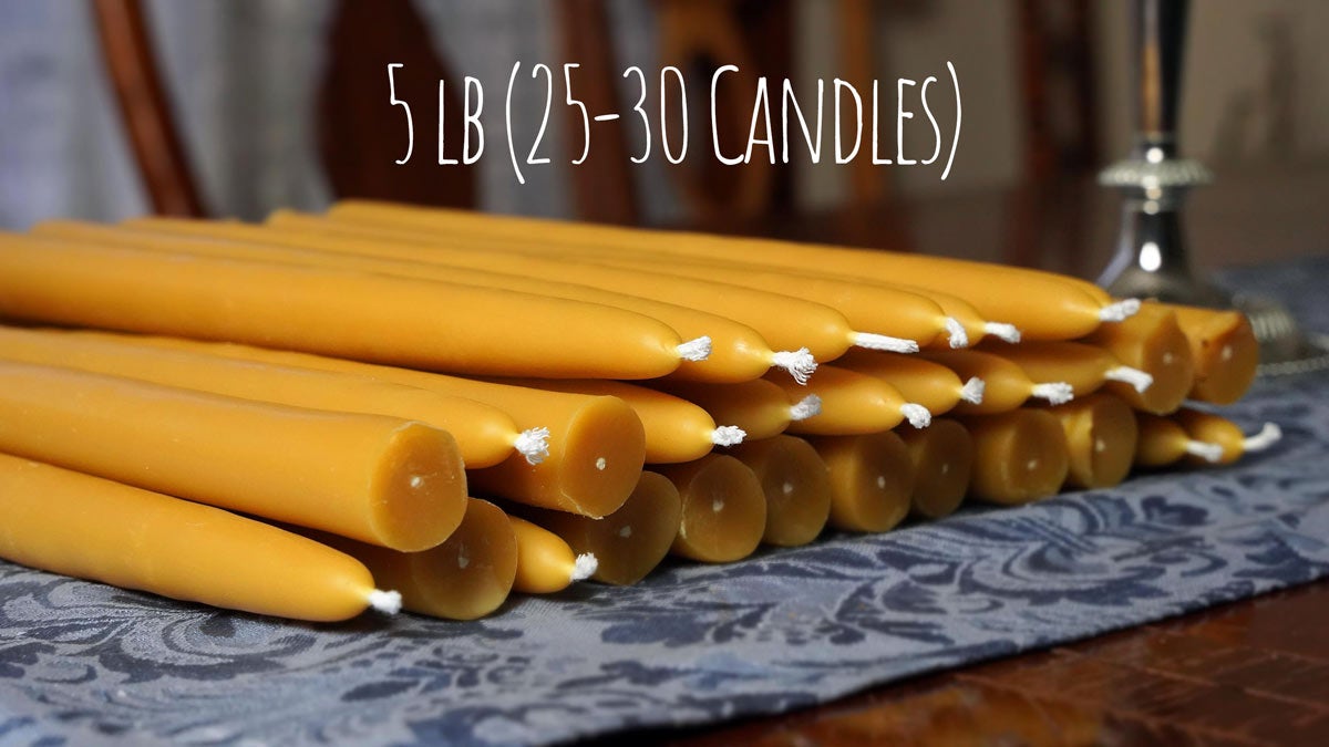 a group of 100% pure beeswax candles on a blue tablecloth